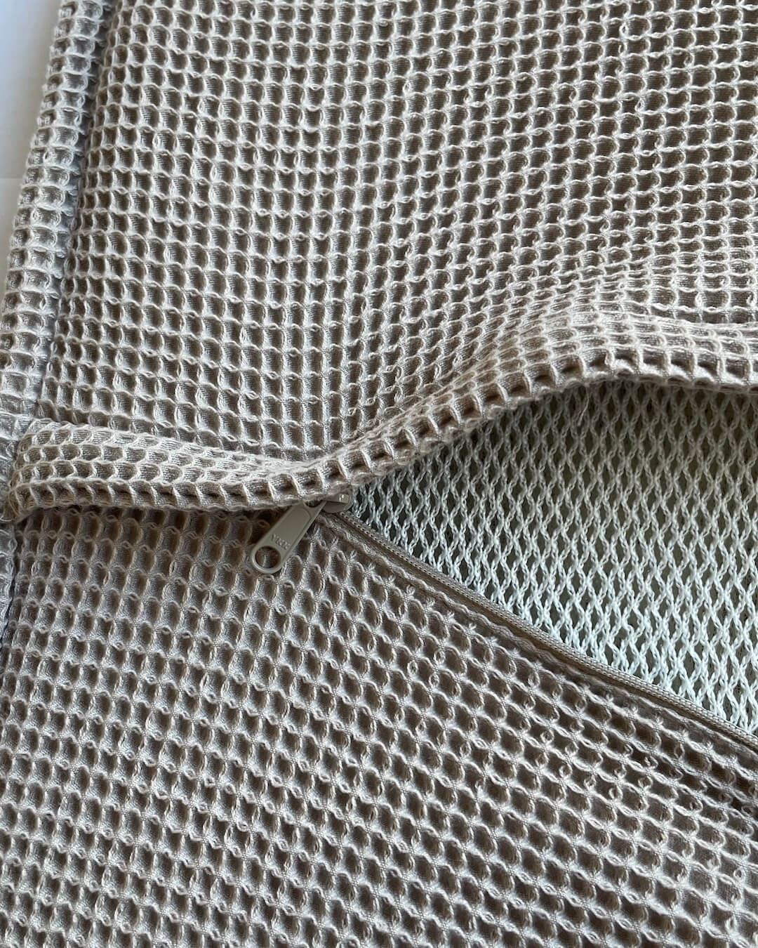 Deatilaufnahme geöffneter Reißverschluss einer Saunaauflage, mit Blick auf das Inlay im Bezug.