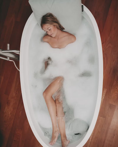 Das Video begleitet eine Frau, die ihr Vollbad mit einem Badesofa Rückenkissen und Fußkissen in einer freistehenden Badewanne genießt